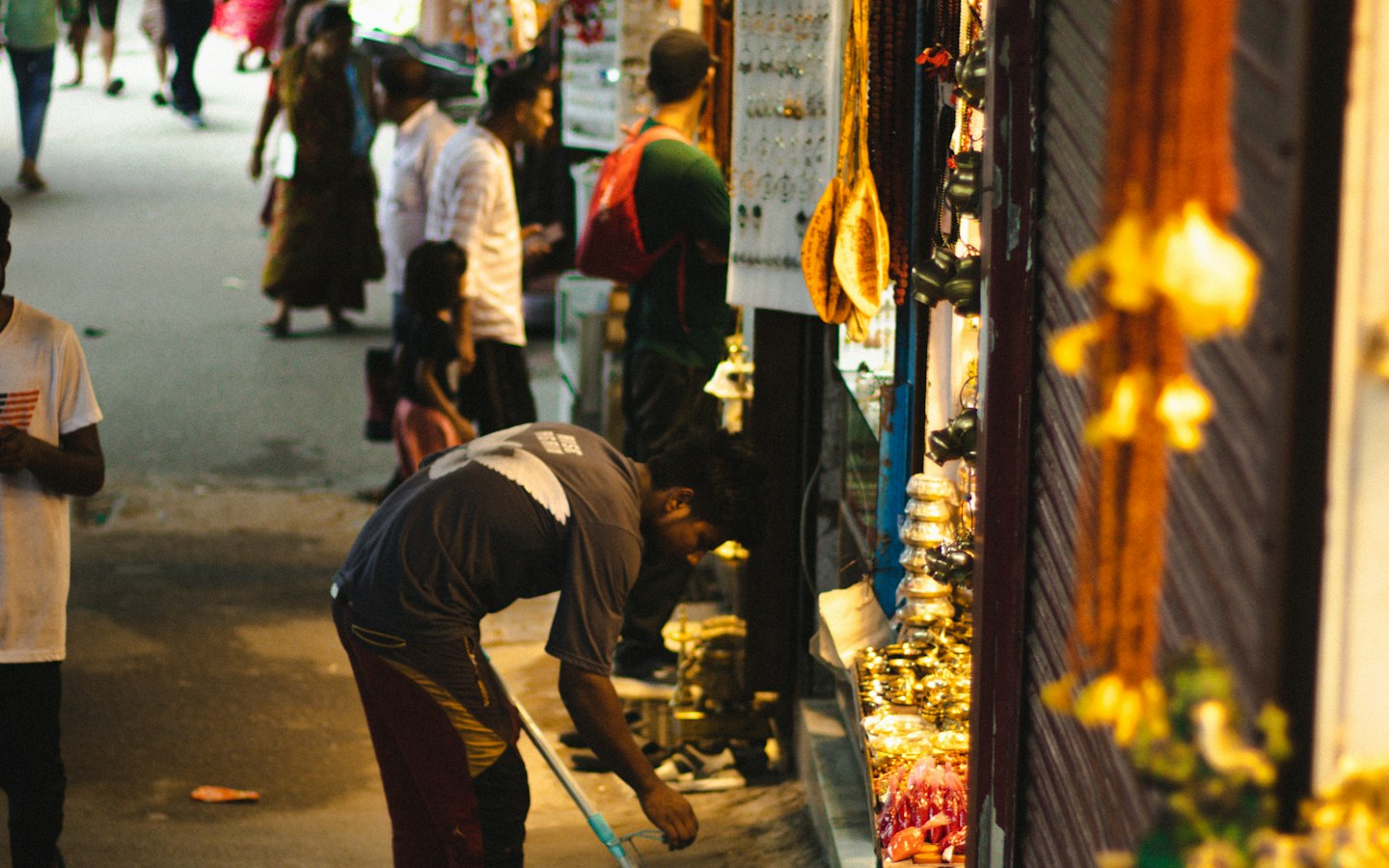 People walking along a market street lined with shops in Rishikesh