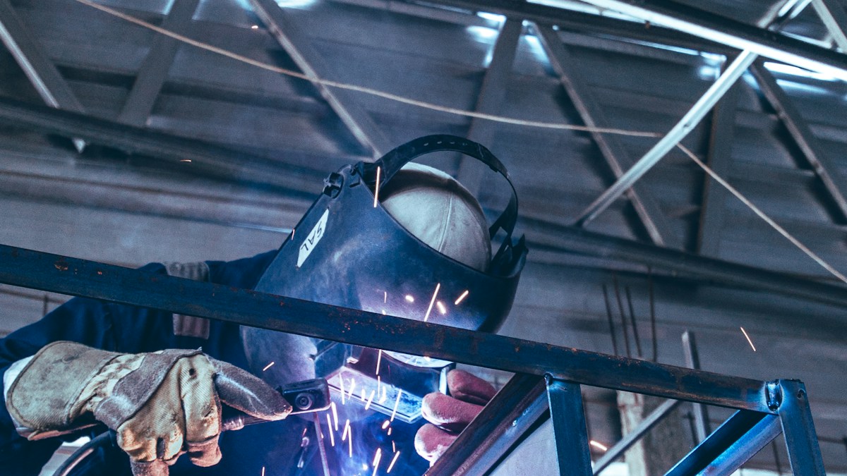 Welder working on metal in a workshop